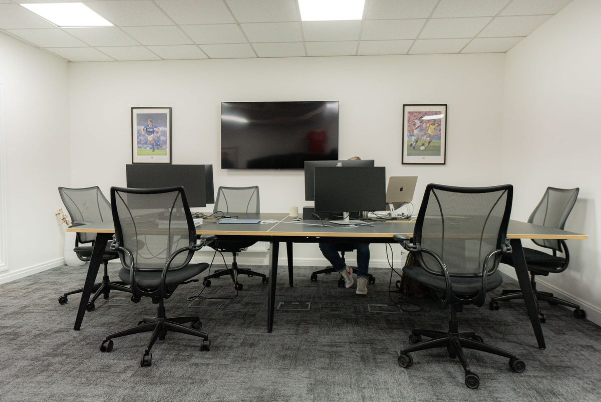 Meeting room fit-out with wall mounted screen and desking